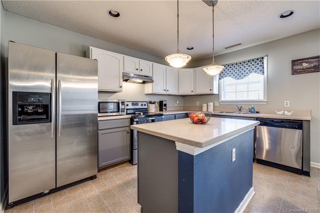 8808 Old Potters Road Charlotte, NC 28269 - Photo 12 of 34 a kitchen with kitchen island a sink stainless steel appliances and a window