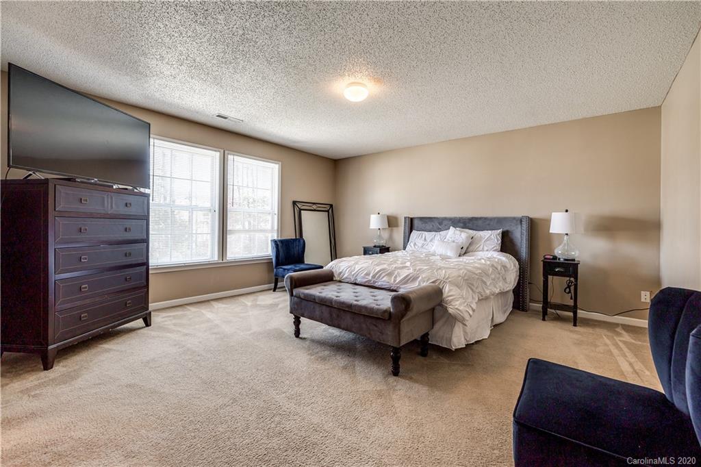 8808 Old Potters Road Charlotte, NC 28269 - Photo 18 of 34 a spacious bedroom with a bed and wooden floor