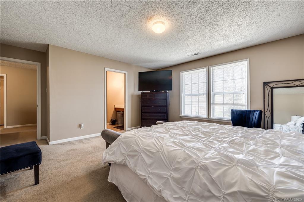 8808 Old Potters Road Charlotte, NC 28269 - Photo 19 of 34 a large bedroom with a bed and a large window