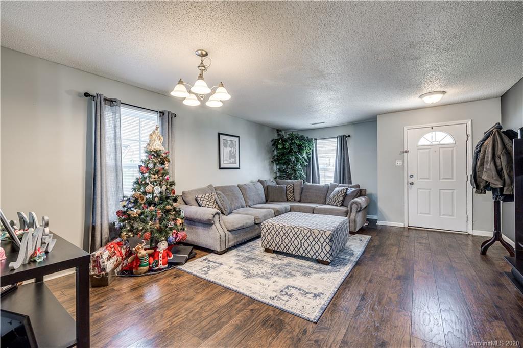8808 Old Potters Road Charlotte, NC 28269 - Photo 4 of 34 a living room with furniture and a chandelier