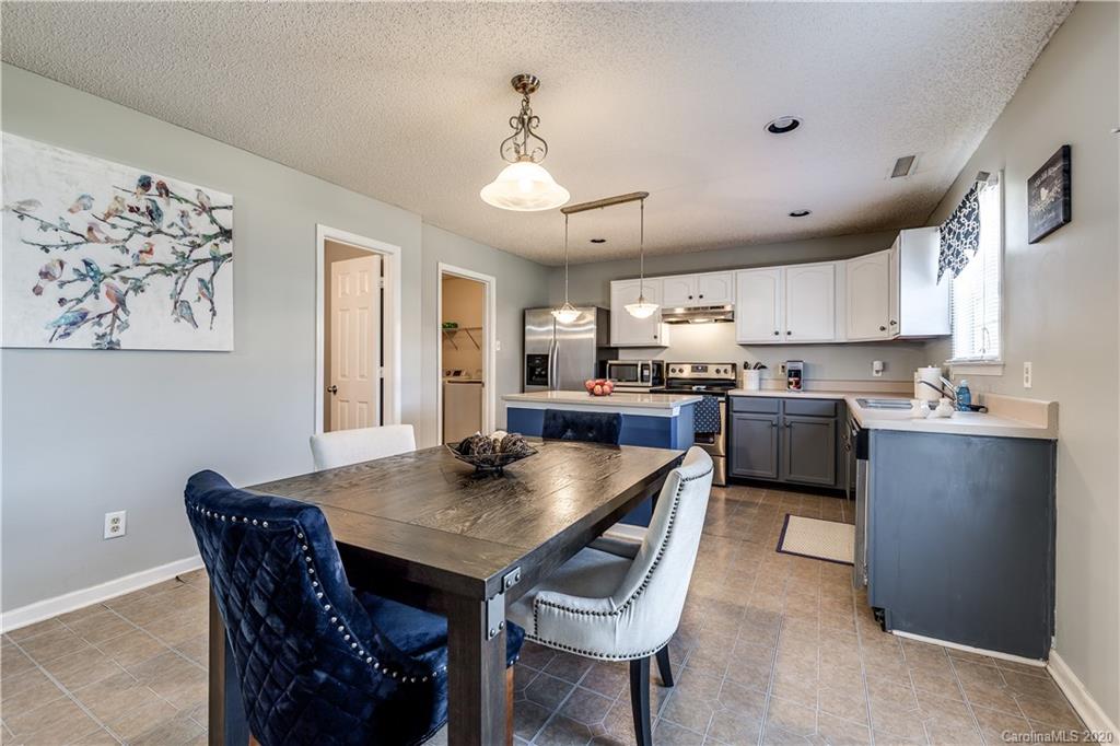 8808 Old Potters Road Charlotte, NC 28269 - Photo 10 of 34 a kitchen with a dining table chairs stainless steel appliances and cabinets