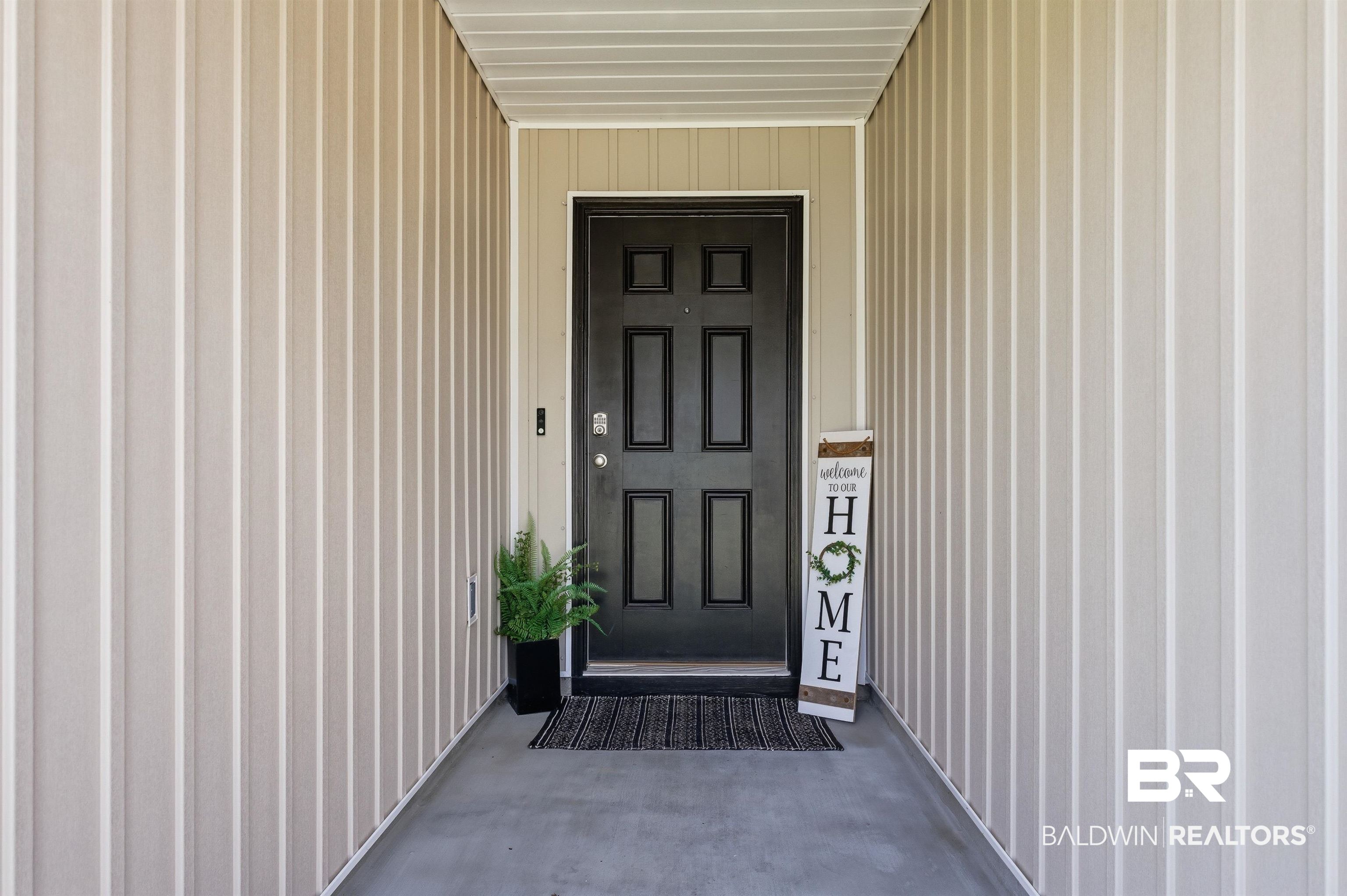 3213 Camino Real Loop Lillian, AL 36549 - Photo 5 of 61 Recessed entry with vertical panel siding and a flat black paneled door