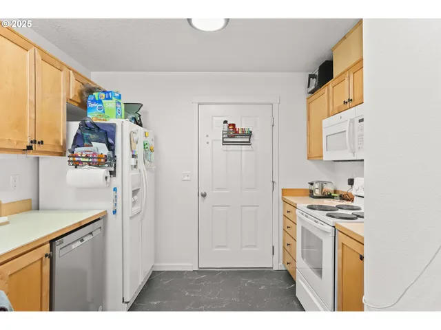 a kitchen with stainless steel appliances white cabinets and a refrigerator