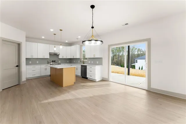 a large kitchen with a lot of cabinets and stainless steel appliances