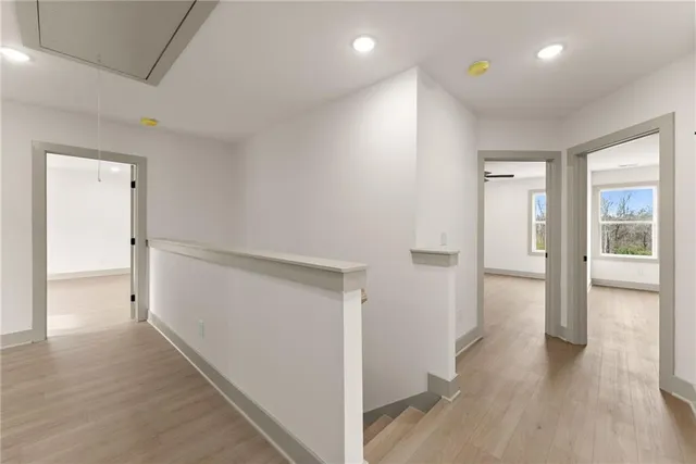 a view of a hallway with wooden floor and closet area