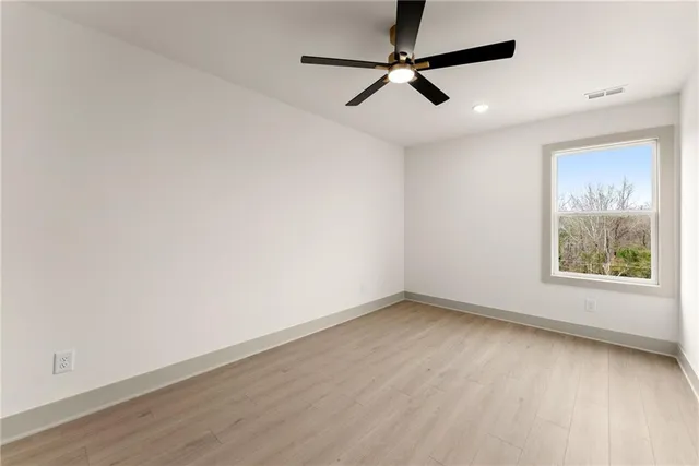 an empty room with a window and a fan
