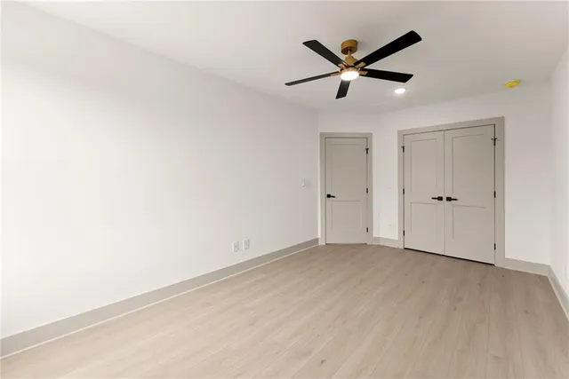 an empty room with ceiling fan and window