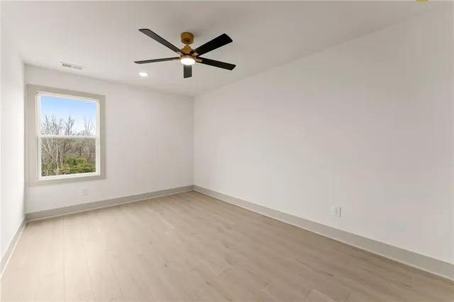 an empty room with a window and a fan