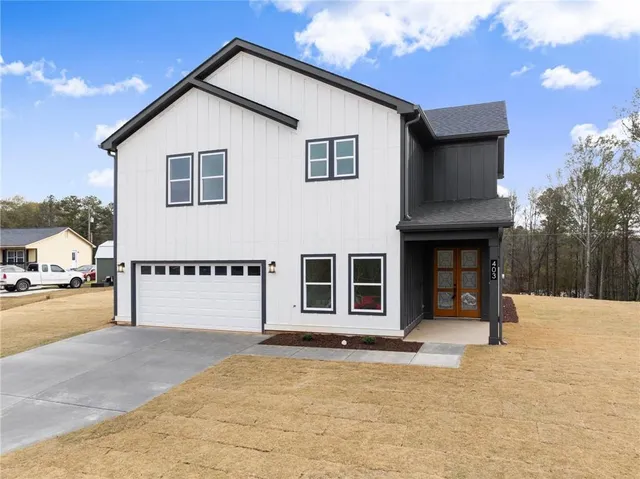 a view of a house with a yard and garage