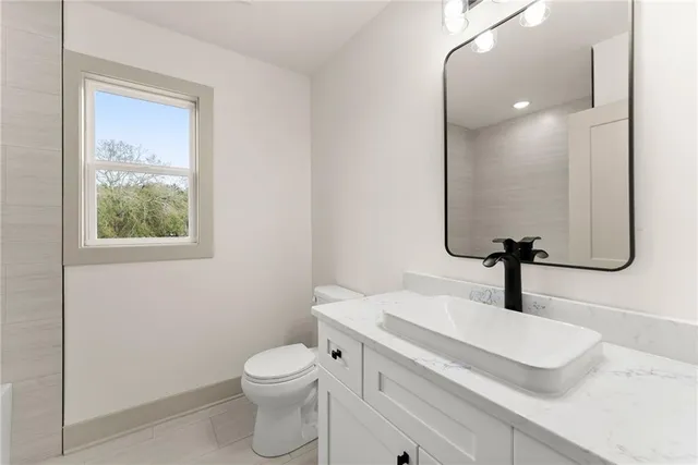 a bathroom with a sink a toilet and mirror