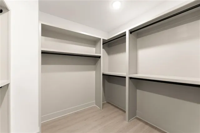 a view of walk in closet with empty racks