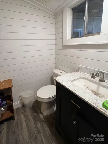 a bathroom with a granite countertop toilet sink and mirror