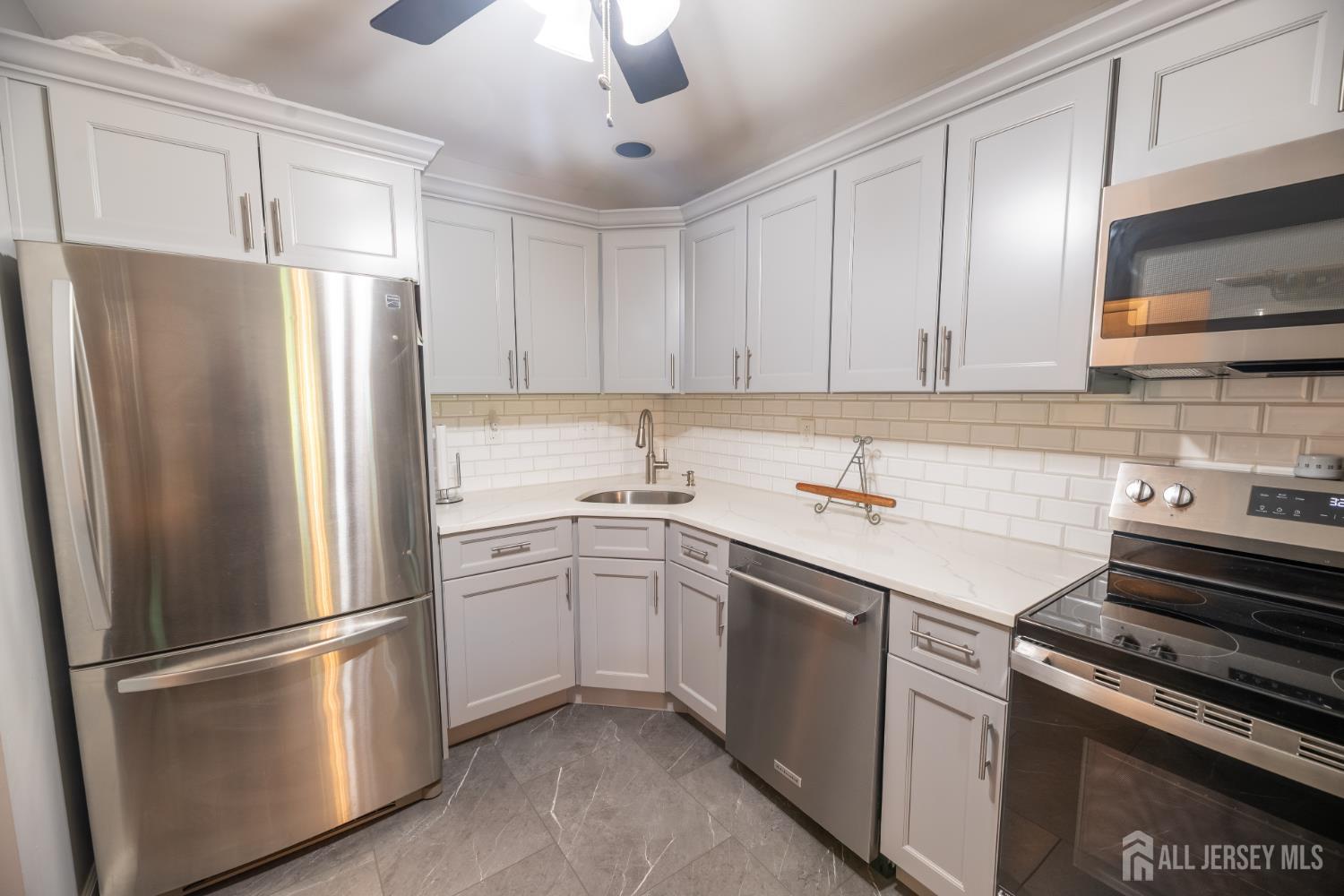 13 Mine Road Jamesburg, NJ 08831 - Photo 14 of 52 a kitchen with stainless steel appliances and refrigerator