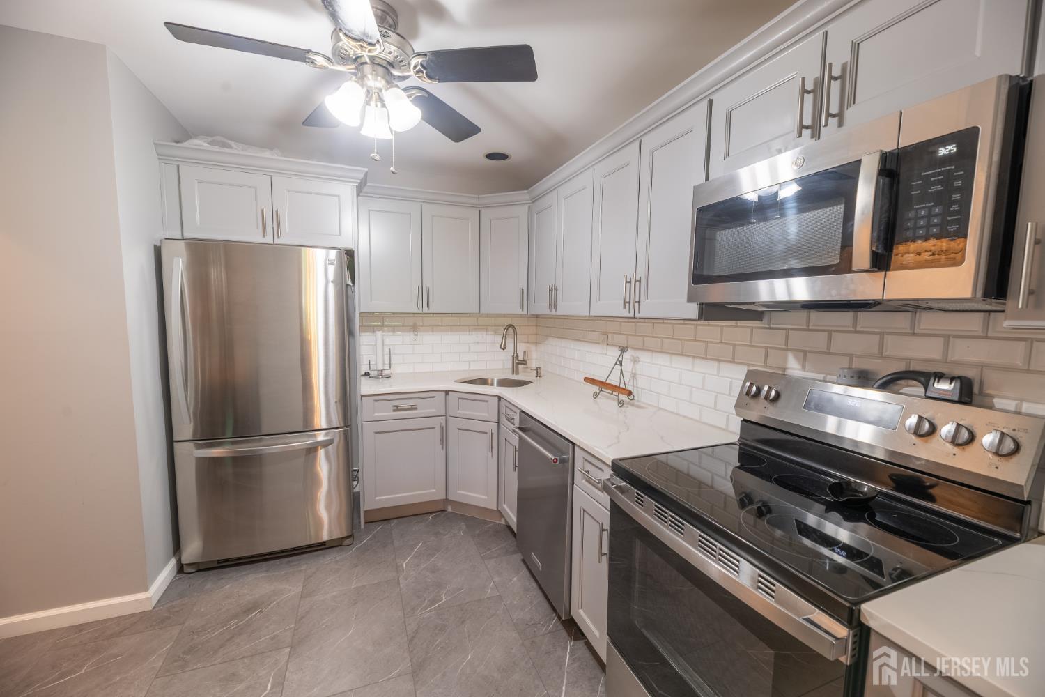 13 Mine Road Jamesburg, NJ 08831 - Photo 16 of 52 a kitchen with a stove refrigerator and microwave