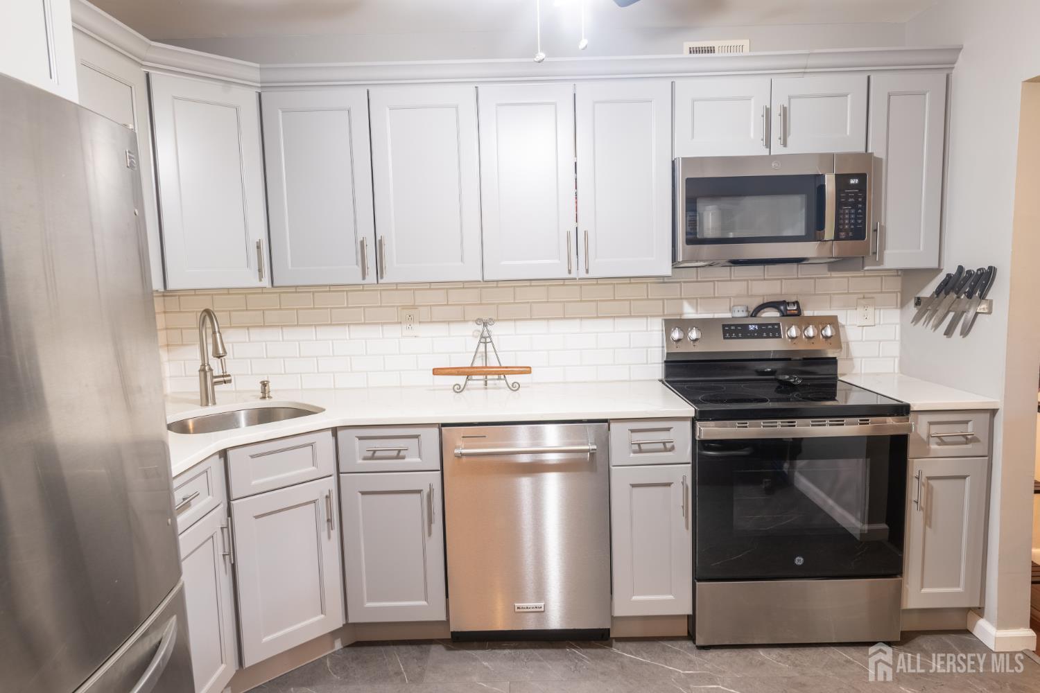 13 Mine Road Jamesburg, NJ 08831 - Photo 17 of 52 a kitchen with white cabinets and stainless steel appliances