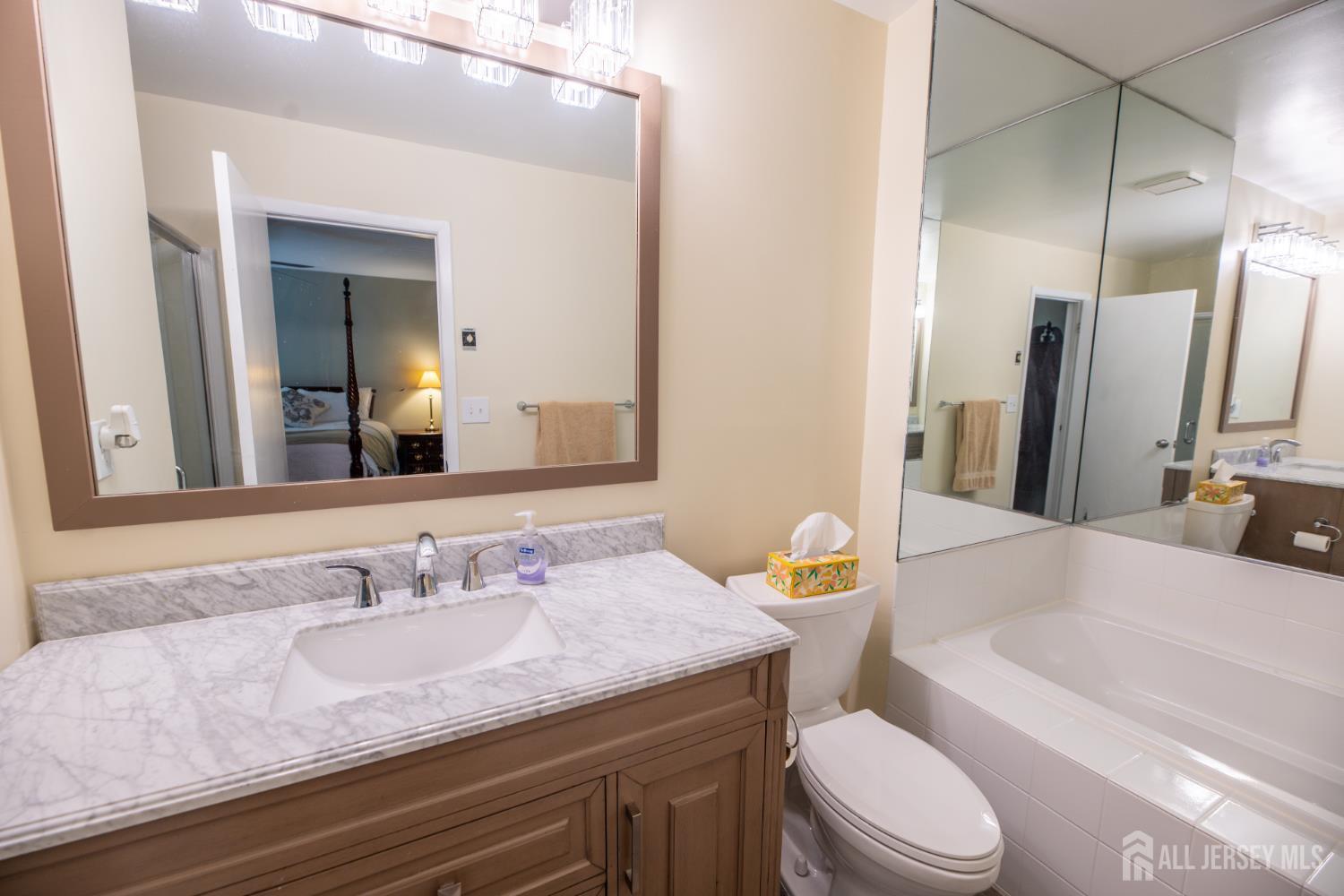 13 Mine Road Jamesburg, NJ 08831 - Photo 32 of 52 a bathroom with a granite countertop sink a toilet a mirror and bathtub