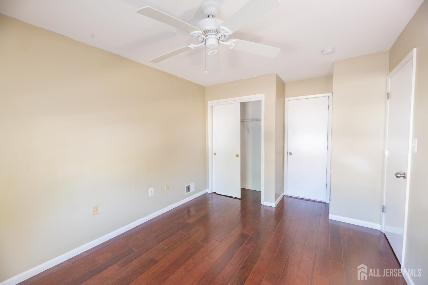 13 Mine Road Jamesburg, NJ 08831 - Photo 38 of 52 an empty room with wooden floor and a ceiling fan