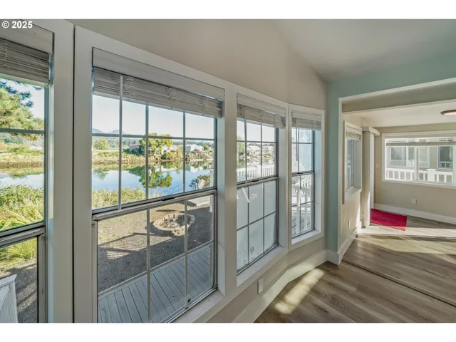 a living room with hardwood floor and floor to ceiling window