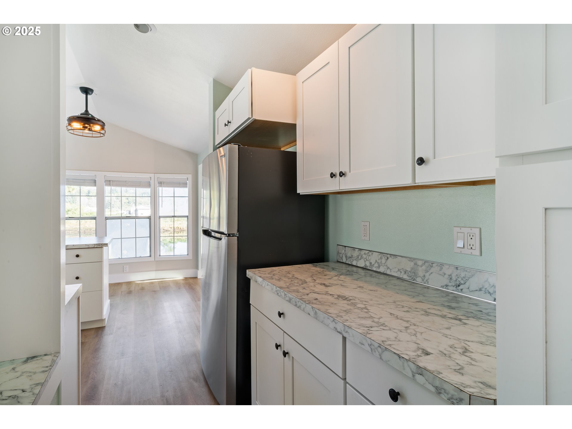 37000 Tohl Ranch Road, Unit 29 Nehalem, OR 97131 - Photo 12 of 46 a kitchen with granite countertop white cabinets and refrigerator