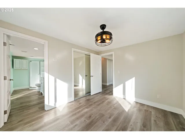 a view of an empty room with wooden floor
