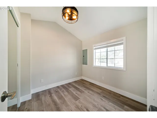 an empty room with wooden floor and a window