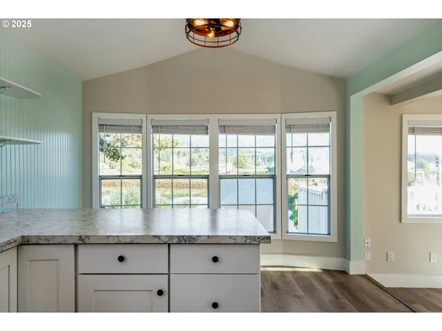 a kitchen with granite countertop a window and a white counter