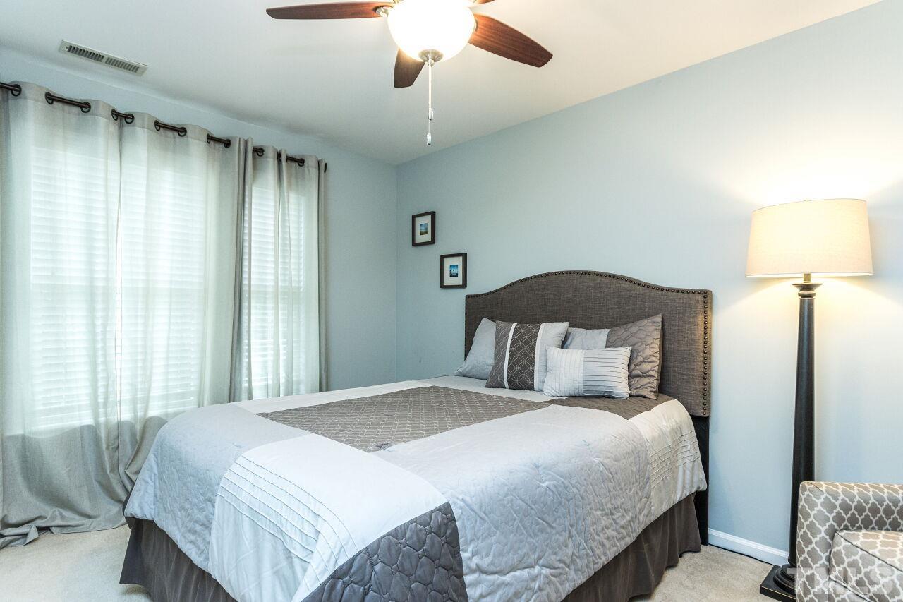 8215 Oneal Road Raleigh, NC 27613 - Photo 16 of 23 a bedroom with a bed and a lamp