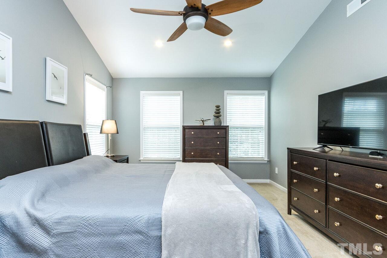 8215 Oneal Road Raleigh, NC 27613 - Photo 22 of 23 a bedroom with a bed and a flat tv screen on dresser