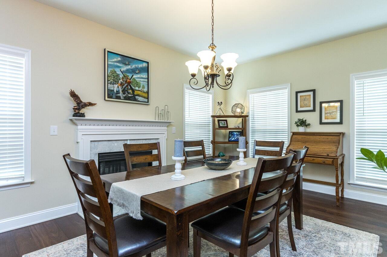 8215 Oneal Road Raleigh, NC 27613 - Photo 5 of 23 a view of a dining room with furniture a chandelier and wooden floor