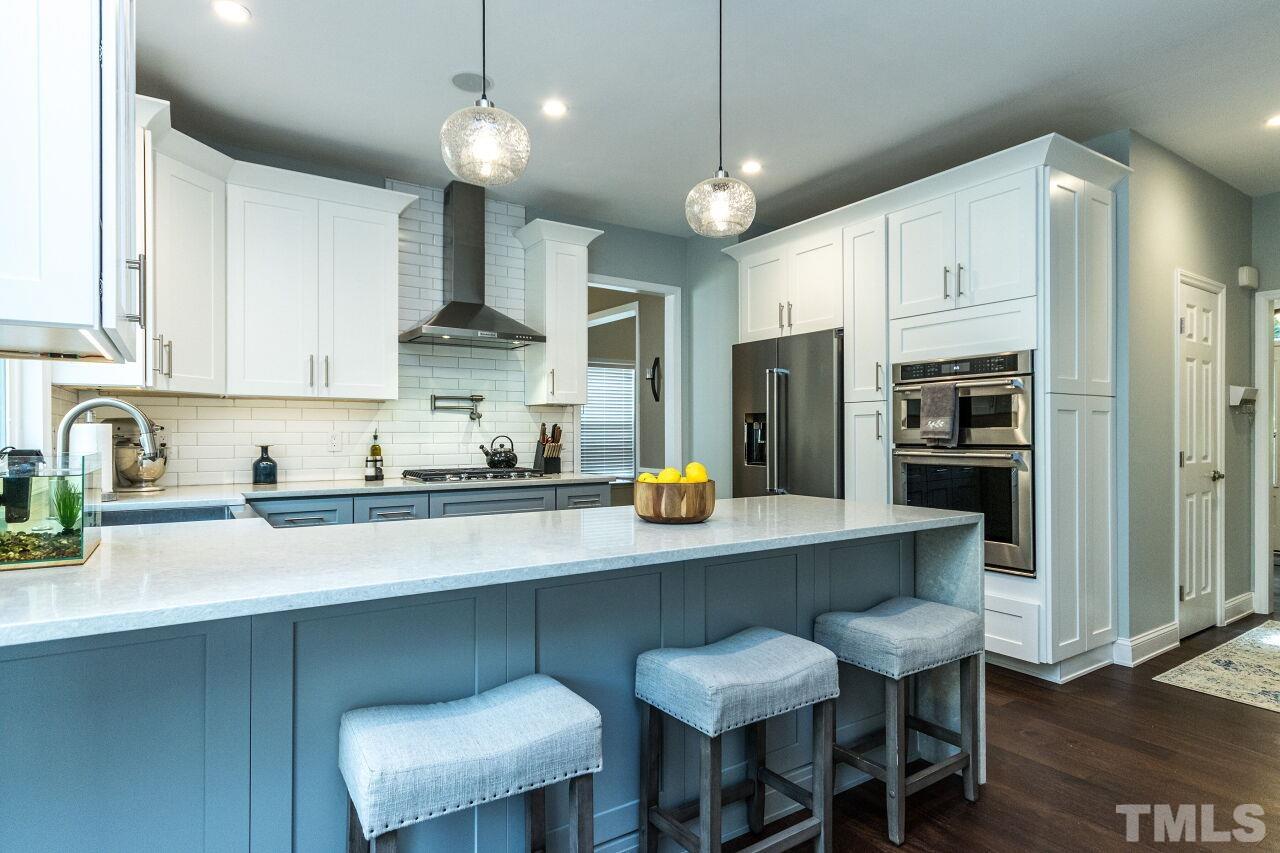 8215 Oneal Road Raleigh, NC 27613 - Photo 9 of 23 a kitchen with stainless steel appliances a table chairs refrigerator and cabinets