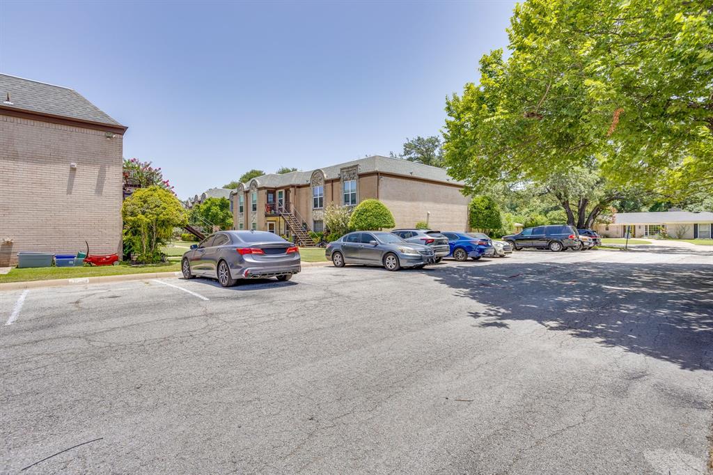 4102 Ridglea Country Club Drive, Unit 1503 Fort Worth, TX 76126 - Photo 20 of 21 Paved parking lot featuring multiple reserved marked spaces