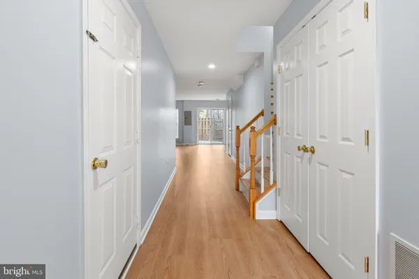 a view of a hallway with wooden floor and staircase