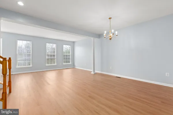 a view of a livingroom with wooden floor and a chandelier