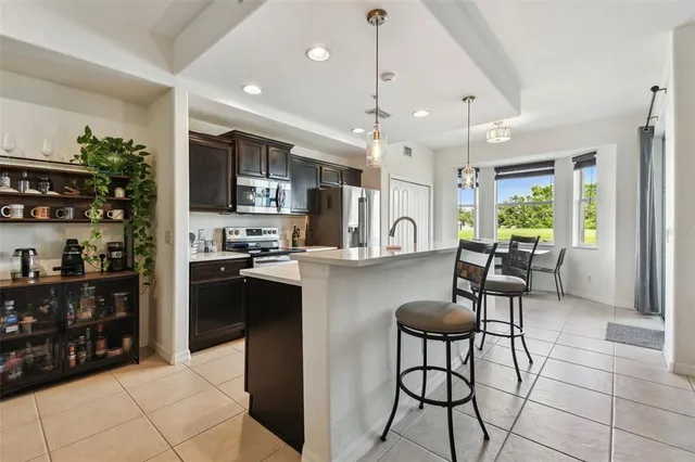 a kitchen with stainless steel appliances kitchen island granite countertop a refrigerator and microwave