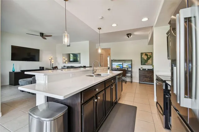 a kitchen with kitchen island a sink appliances and a counter top space