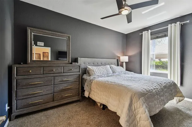 a bedroom with a bed and a mirror on the dresser