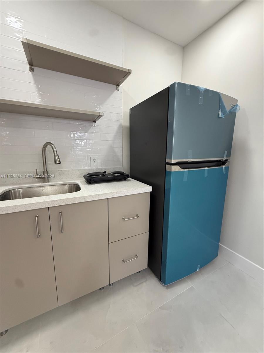 3445 Southwest 62nd Way, Unit 3445 Miramar, FL 33023 - Photo 3 of 6 a kitchen with a refrigerator and a sink