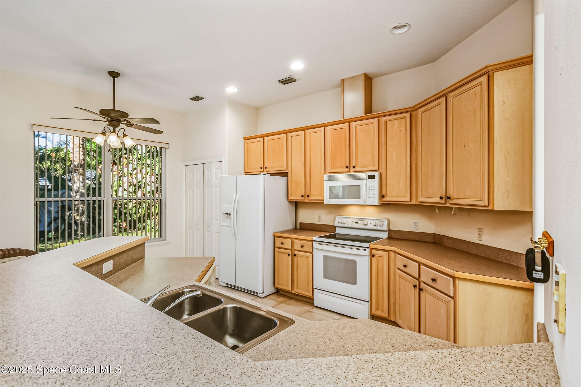 216 3rd Avenue Indialantic, FL 32903 - Photo 14 of 37 a kitchen with stainless steel appliances granite countertop a sink stove and refrigerator