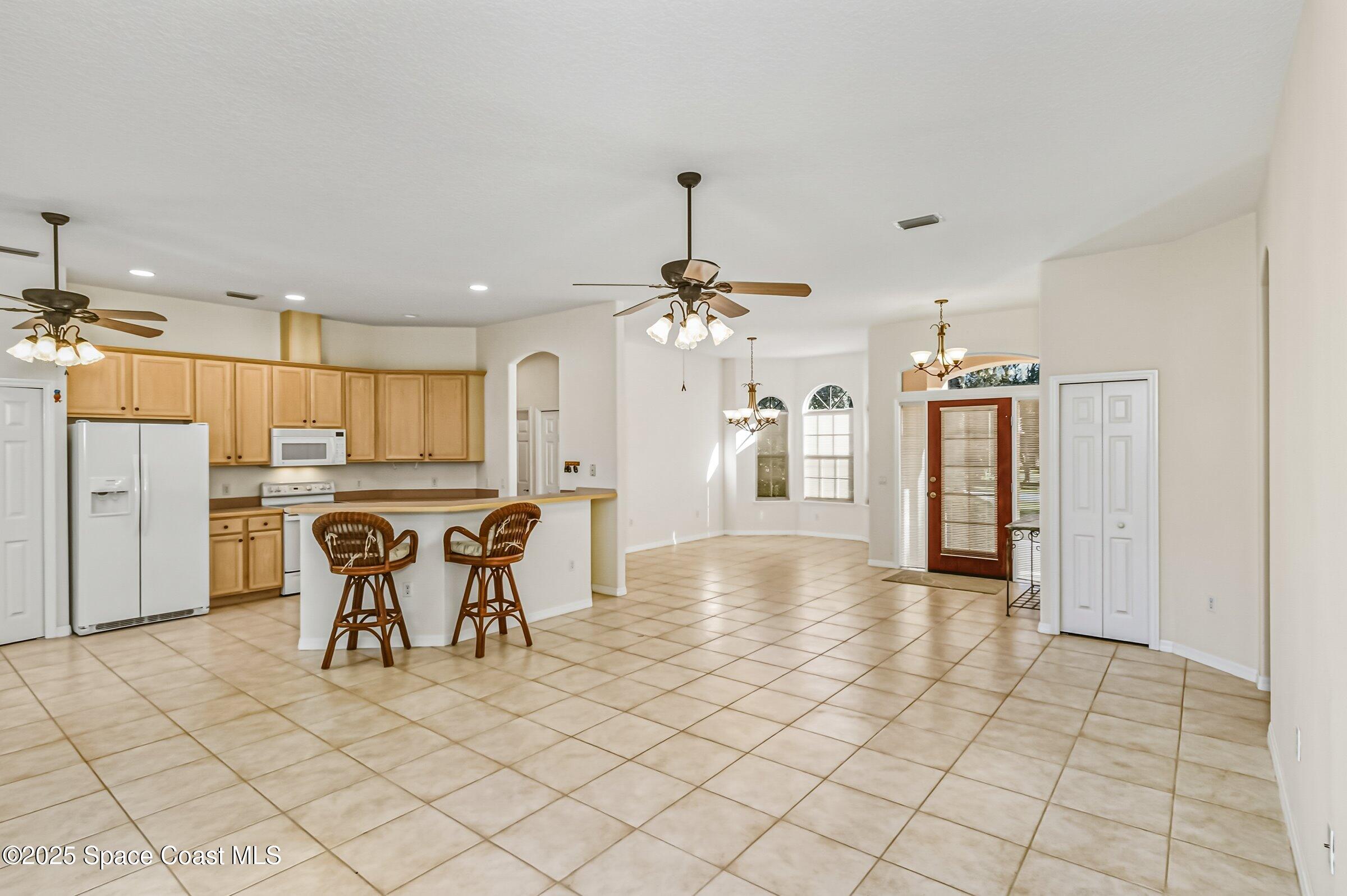 216 3rd Avenue Indialantic, FL 32903 - Photo 9 of 37 a view of a kitchen with kitchen island white cabinets and refrigerator