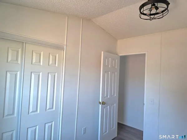 a view of a closet area with wooden floor