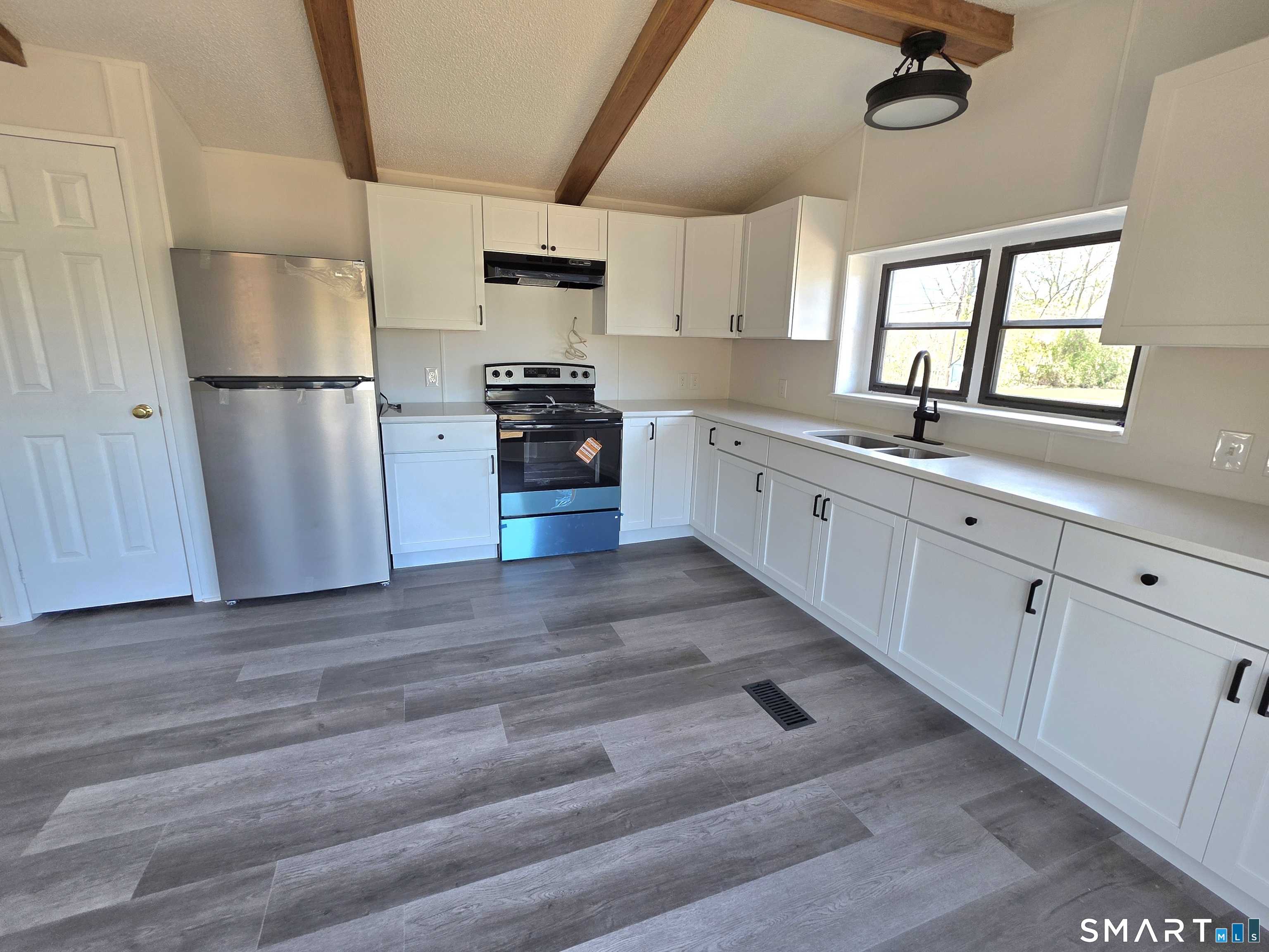 500 Washington Street, Unit 5 Middletown, CT 06457 - Photo 5 of 19 a kitchen with granite countertop a refrigerator a sink dishwasher a stove and white cabinets with wooden floor