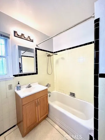 a bathroom with a tub a sink and a mirror