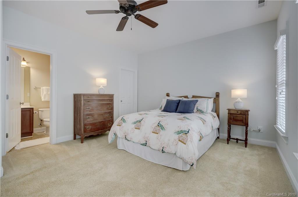 170 Mills Lane, Unit 761 Fort Mill, SC 29708 - Photo 28 of 35 a spacious bedroom with a bed and a chandelier