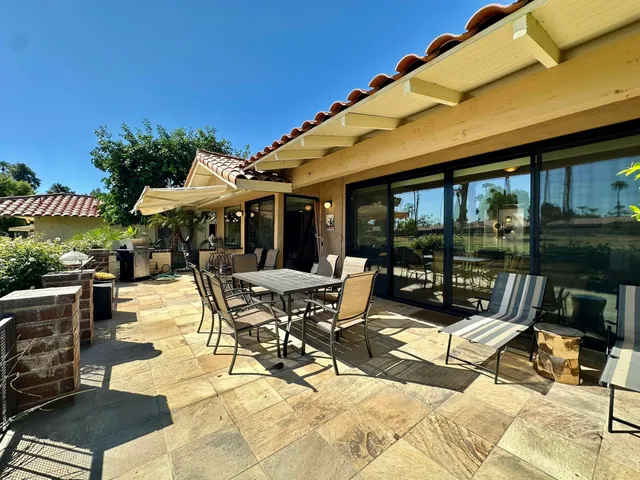 a view of a patio with table and chairs under an umbrella