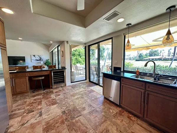 a large kitchen with kitchen island granite countertop a large window and a sink