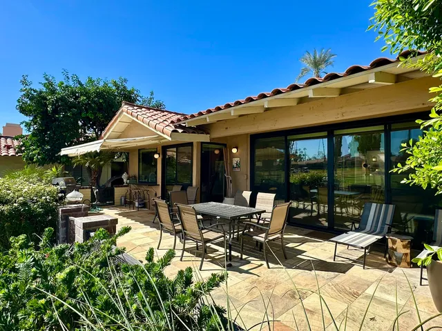 a view of a house with backyard sitting area and garden