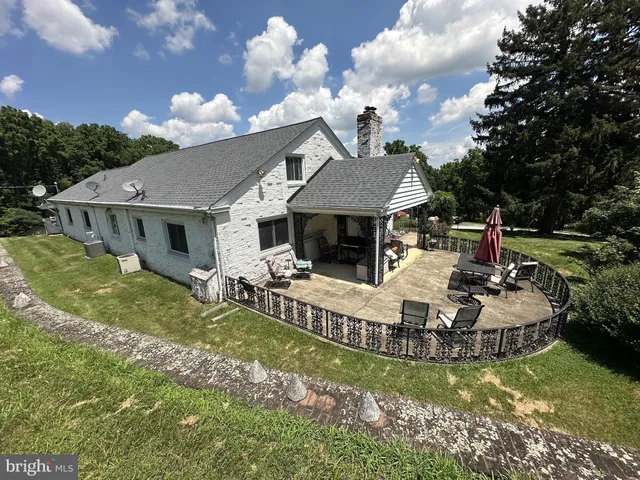 a white house covered with tall trees