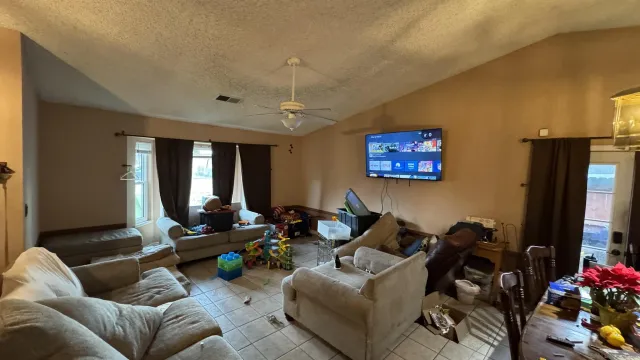 a living room with furniture a flat screen tv and a window