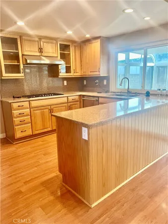 a large kitchen with stainless steel appliances granite countertop a sink and cabinets