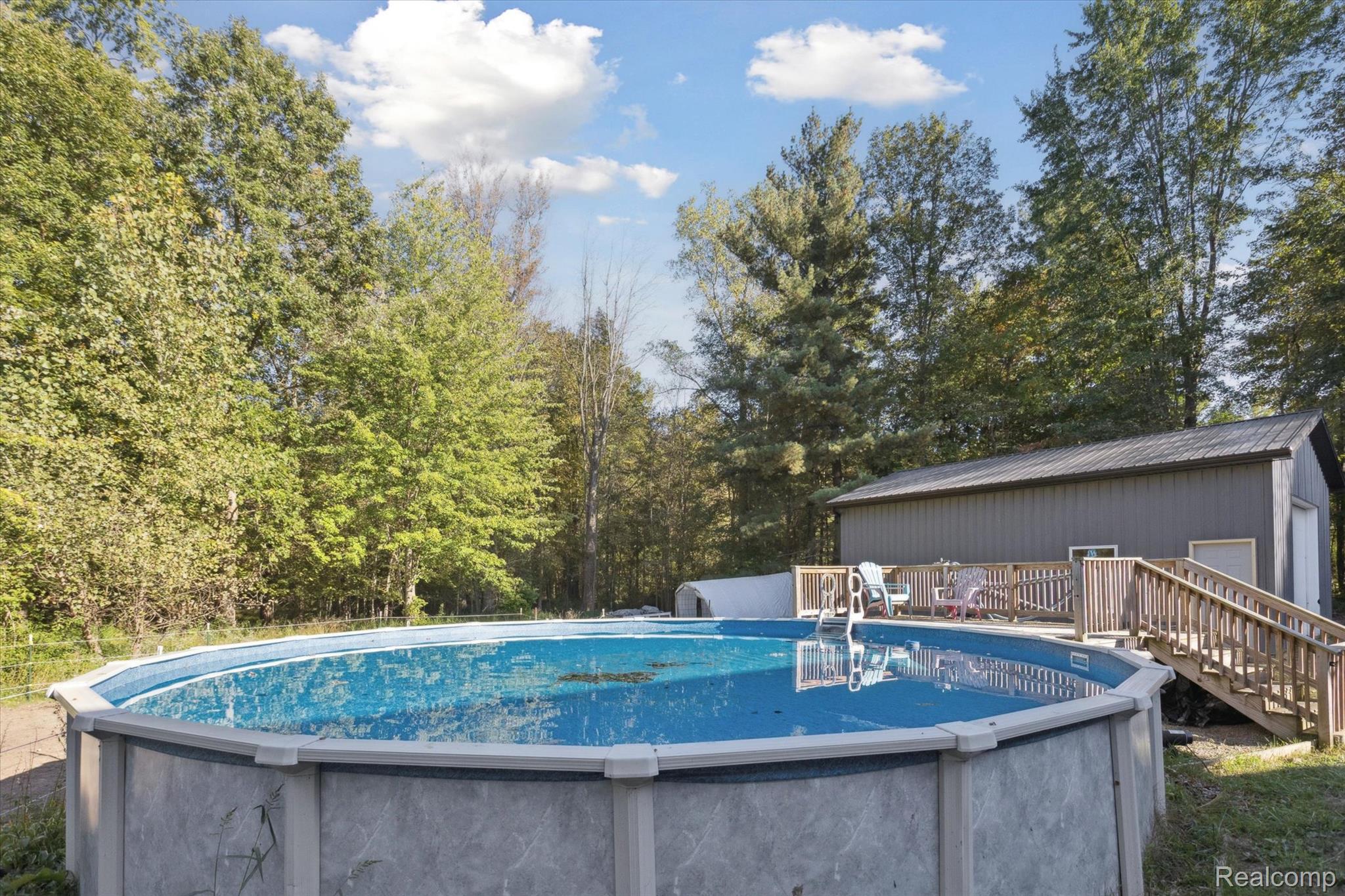 10147 South Bray Road Clio, MI 48420 - Photo 43 of 57 Swimming pool featuring a deck and view of scattered trees